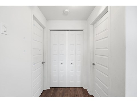 A white door with a white wall and a brown floor.