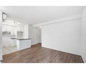 A kitchen with white cabinets and a wooden floor.
