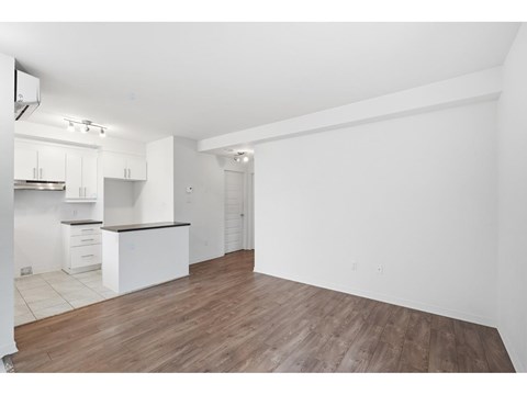 A kitchen with white cabinets and a wooden floor.