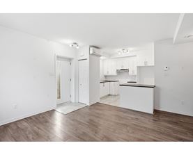 A kitchen with white cabinets and a black countertop.