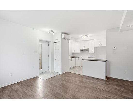 A kitchen with white cabinets and a black countertop.