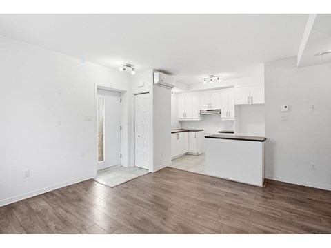 A kitchen with white cabinets and a black countertop.
