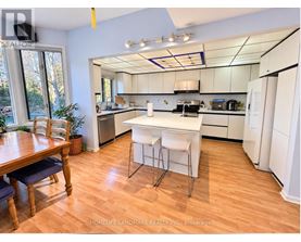 A kitchen with white appliances and a wooden table.