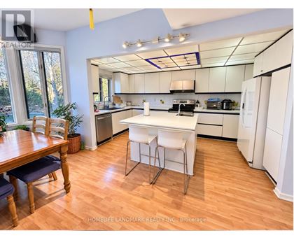 A kitchen with white appliances and a wooden table.