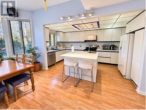 A kitchen with white appliances and a wooden table.