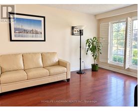 A living room with a couch, a floor lamp, and a plant.