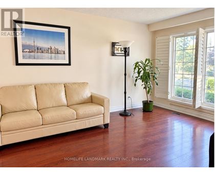 A living room with a couch, a floor lamp, and a plant.
