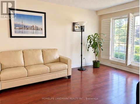 A living room with a couch, a floor lamp, and a plant.