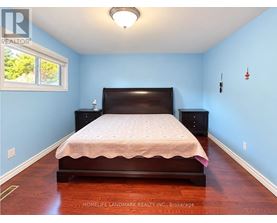 A bedroom with a bed, dresser, and window.