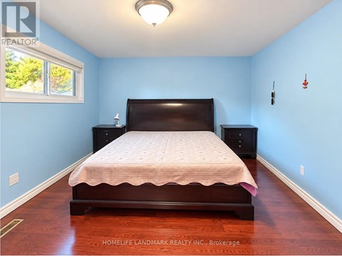 A bedroom with a bed, dresser, and window.