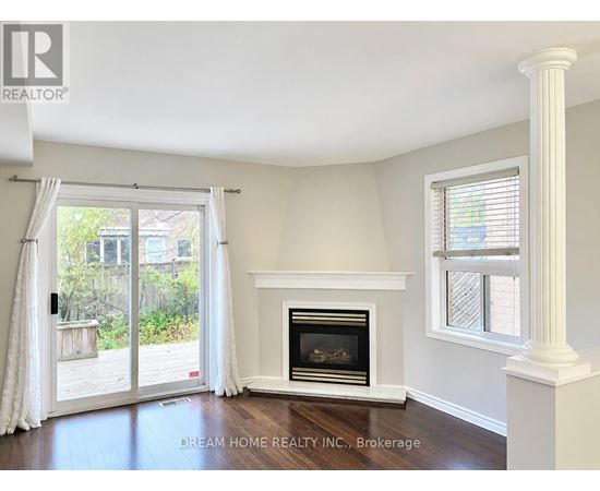 A room with a fireplace and a sliding glass door leading to a backyard.