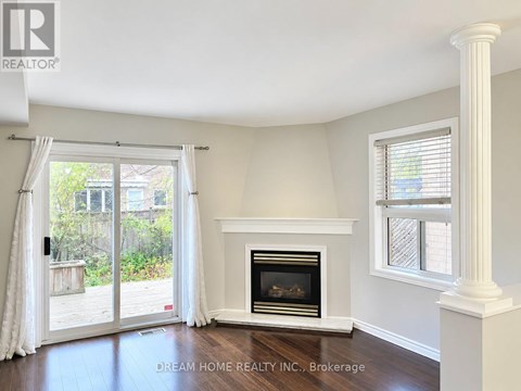 A room with a fireplace and a sliding glass door leading to a backyard.