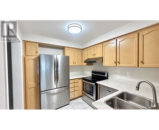 A kitchen with wooden cabinets and stainless steel appliances.