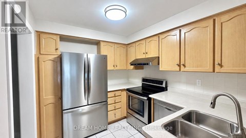 A kitchen with wooden cabinets and stainless steel appliances.