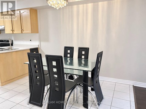 A dining room with a table and four chairs.