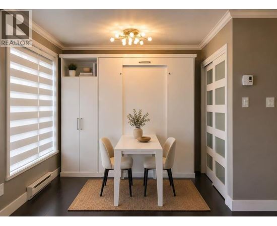 A dining room with a white table and chairs.