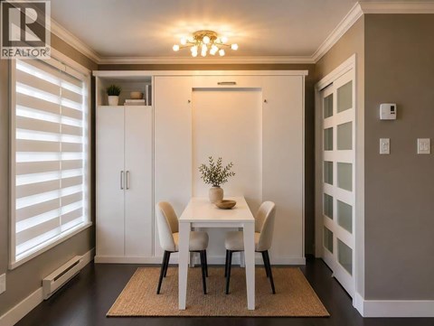 A dining room with a white table and chairs.