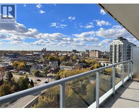 A balcony overlooks a cityscape with buildings and trees.
