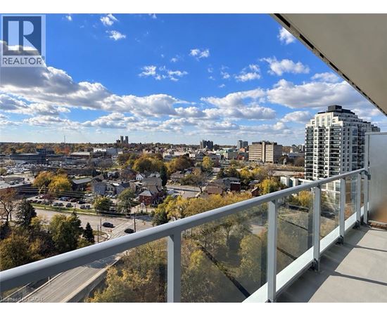 A balcony overlooks a cityscape with buildings and trees.