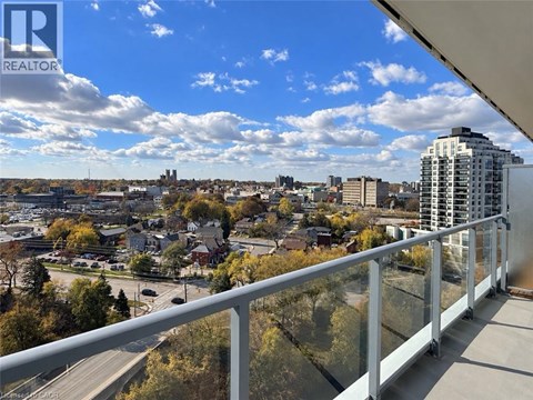 A balcony overlooks a cityscape with buildings and trees.