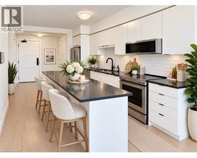 A modern kitchen with white cabinets and a black countertop.