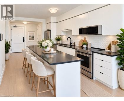 A modern kitchen with white cabinets and a black countertop.