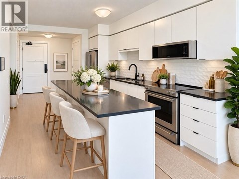 A modern kitchen with white cabinets and a black countertop.