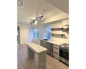 A modern kitchen with stainless steel appliances and a marble island.