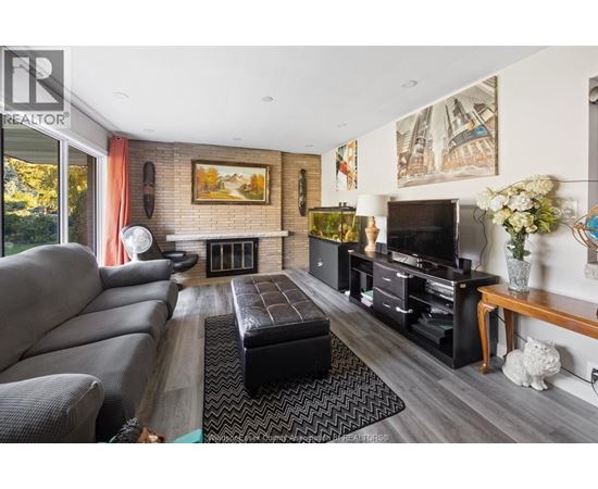 A living room with a grey couch and a fireplace.