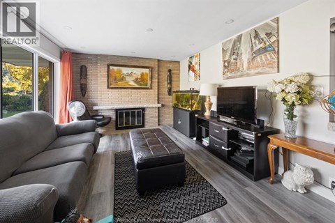 A living room with a grey couch and a fireplace.