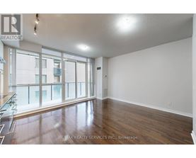 A spacious room with wooden floors and large windows.