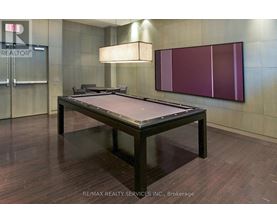 A pool table in a room with a wooden floor and a purple wall.