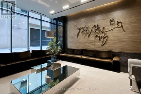 A modern living room with a glass table and a brown couch.
