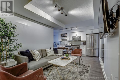 A modern living room with a grey sofa, a coffee table, and a television mounted on the wall.
