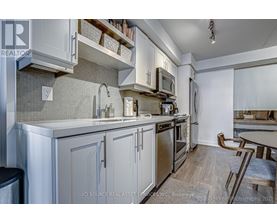 A kitchen with white cabinets and a grey backsplash.