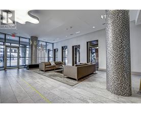 A spacious lobby with a patterned column and a couch.