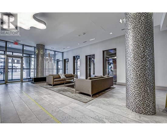 A spacious lobby with a patterned column and a couch.