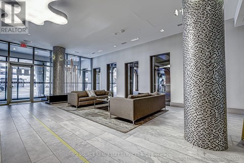 A spacious lobby with a patterned column and a couch.