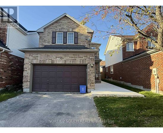A house with a garage door and a blue bin in front of it.