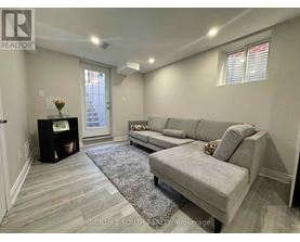 A living room with a grey couch and a grey rug.