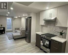 A modern kitchen with a refrigerator, oven, and stove top.