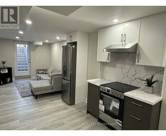 A modern kitchen with a refrigerator, oven, and stove top.