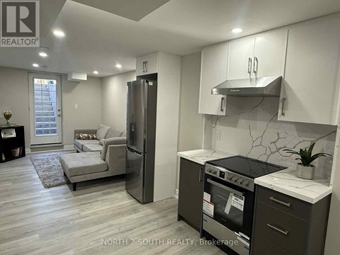 A modern kitchen with a refrigerator, oven, and stove top.