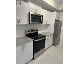 A kitchen with white cabinets and a black stove top oven.