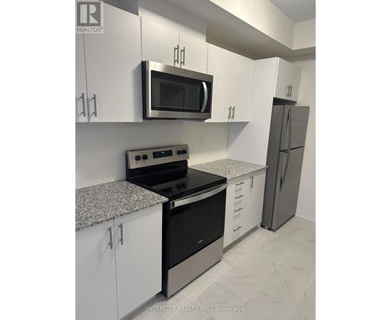 A kitchen with white cabinets and a black stove top oven.