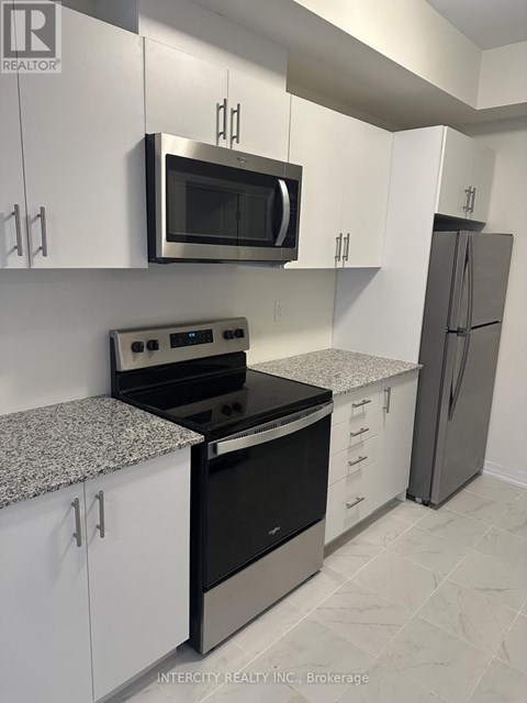 A kitchen with white cabinets and a black stove top oven.