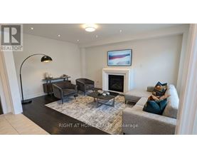 A living room with a grey couch, a black floor lamp, and a fireplace.