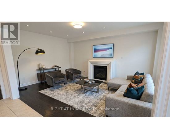 A living room with a grey couch, a black floor lamp, and a fireplace.