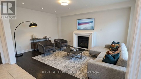 A living room with a grey couch, a black floor lamp, and a fireplace.