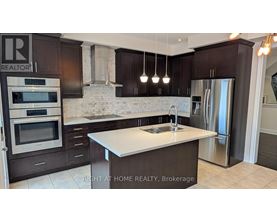 A modern kitchen with dark brown cabinets and stainless steel appliances.